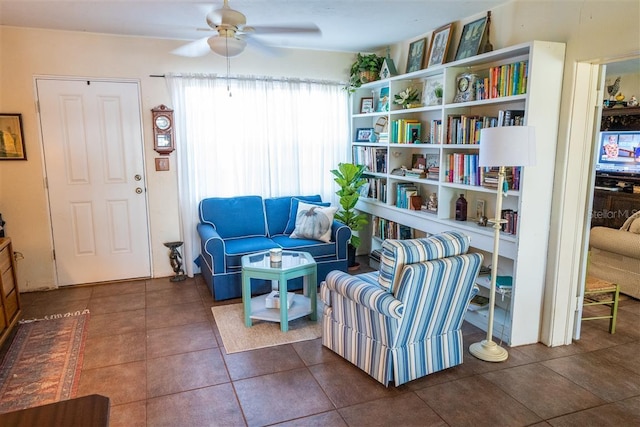 sitting room with dark tile patterned flooring and ceiling fan