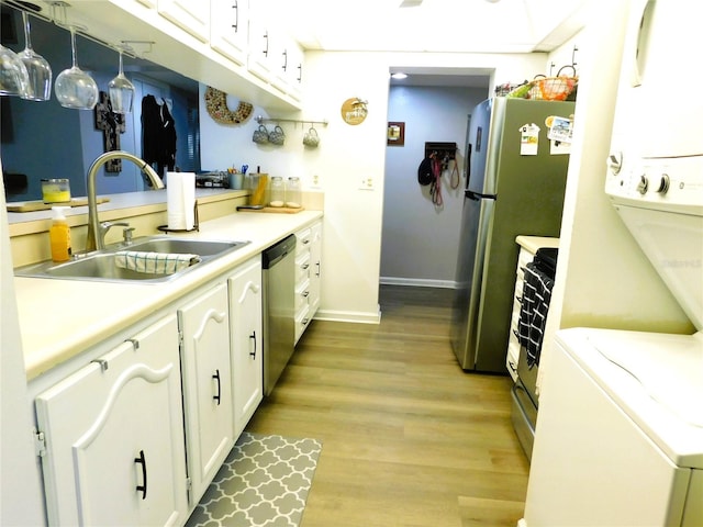 kitchen with decorative light fixtures, white cabinetry, light hardwood / wood-style floors, sink, and stainless steel appliances