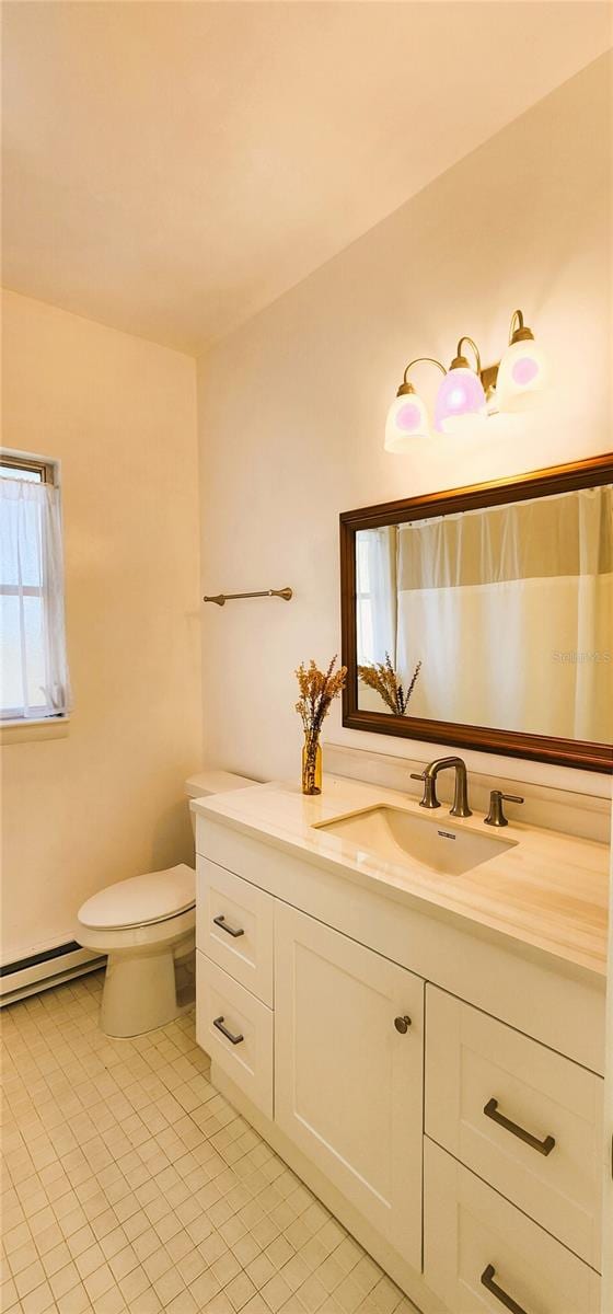 bathroom with a baseboard radiator, vanity, and toilet