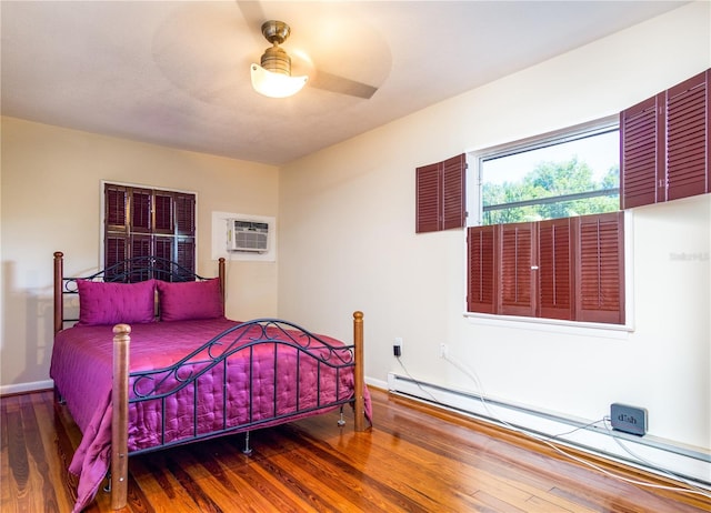 bedroom with hardwood / wood-style floors, a wall mounted AC, ceiling fan, and baseboard heating