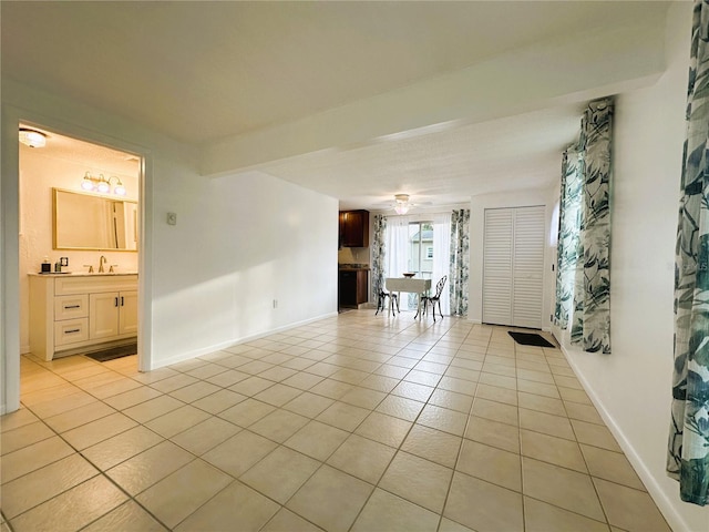 unfurnished living room featuring sink and light tile patterned floors