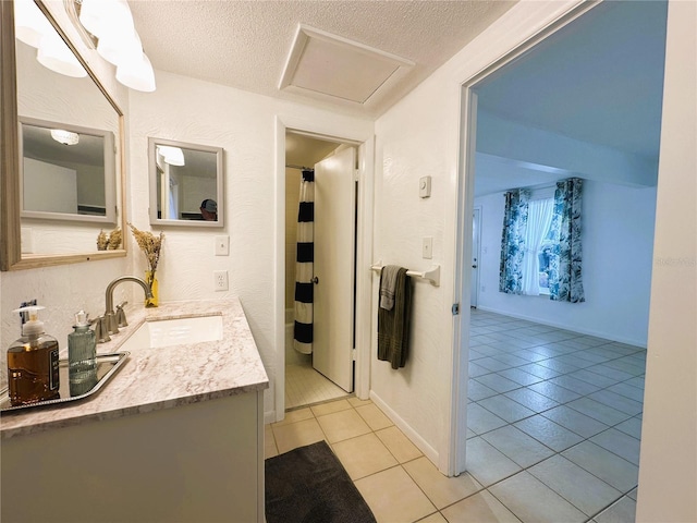 bathroom featuring tile patterned floors, vanity, and a textured ceiling