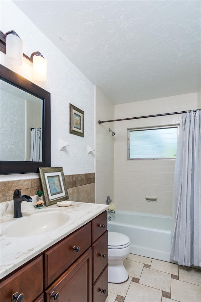 full bathroom with shower / bath combination with curtain, vanity, toilet, tile patterned floors, and a textured ceiling