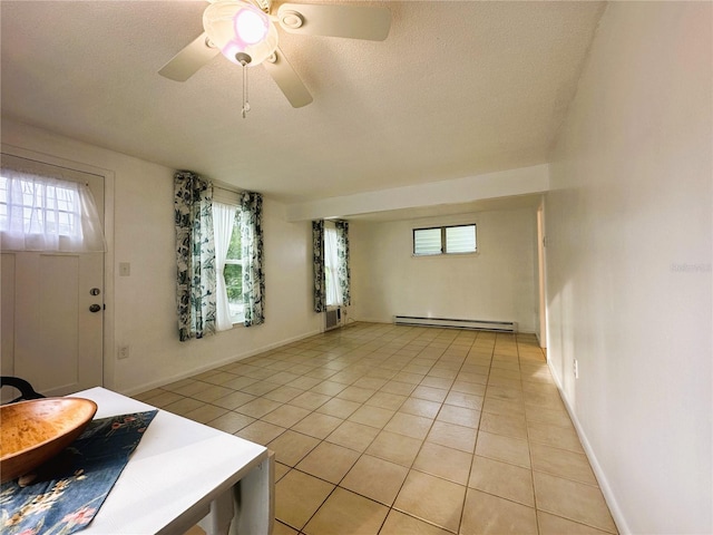 interior space with baseboard heating, ceiling fan, a textured ceiling, and a wealth of natural light