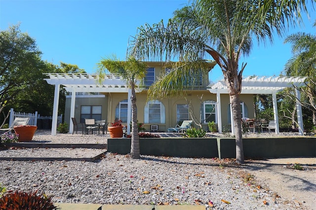 rear view of property with a pergola