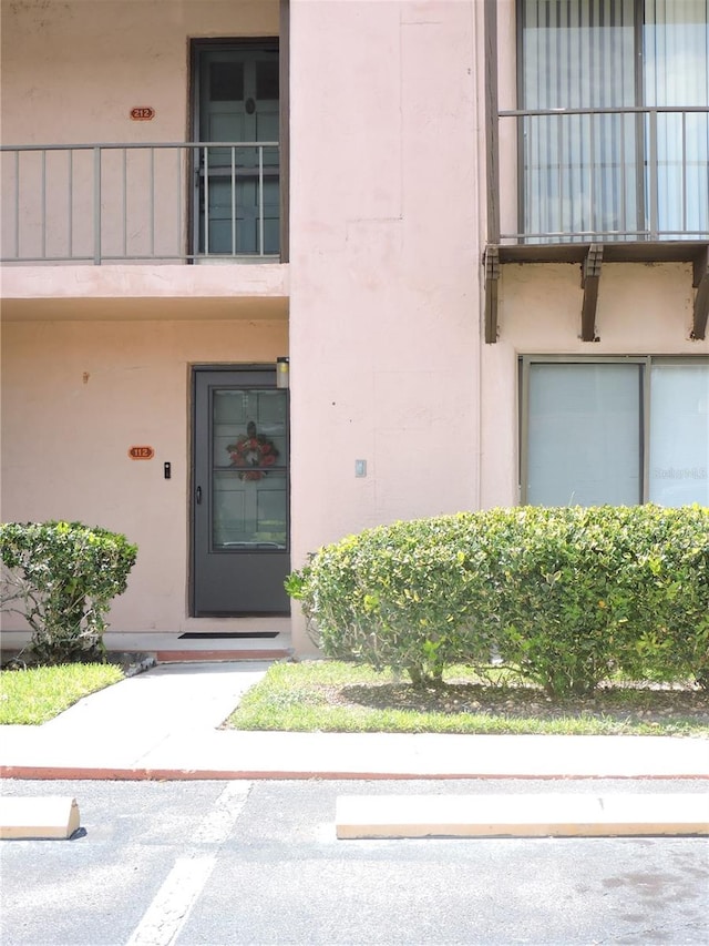 view of exterior entry featuring a balcony