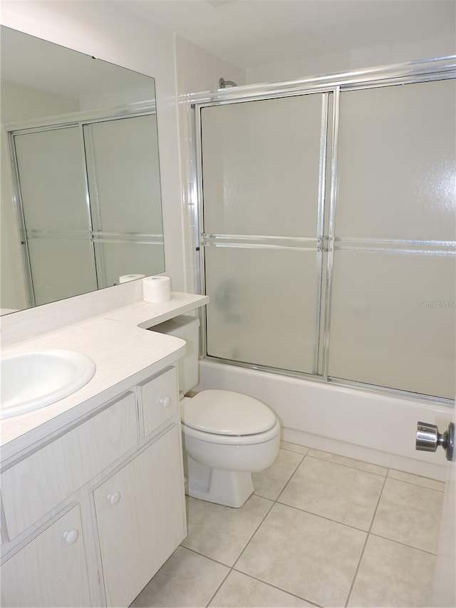 full bathroom featuring tile floors, combined bath / shower with glass door, vanity, and toilet