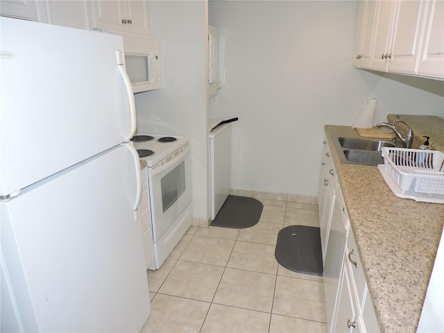 kitchen featuring white appliances, light stone counters, light tile floors, sink, and white cabinetry