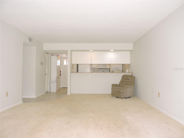 unfurnished living room with light colored carpet