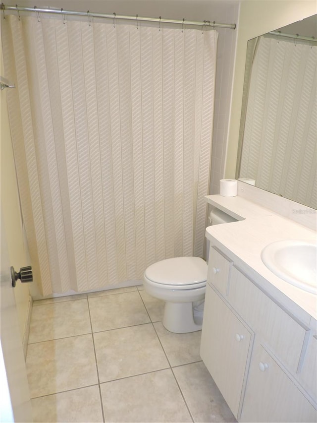 bathroom with vanity, toilet, and tile floors