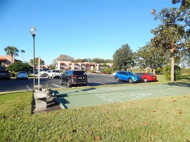 view of vehicle parking with a lawn