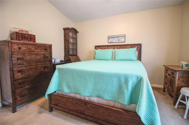 bedroom with light colored carpet and vaulted ceiling