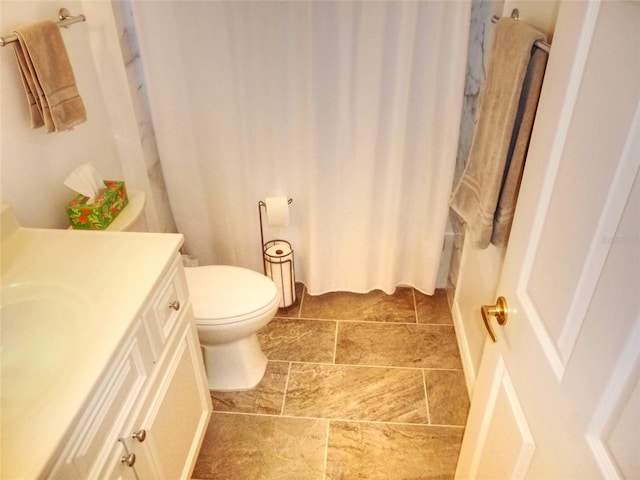 bathroom featuring walk in shower, vanity, and toilet