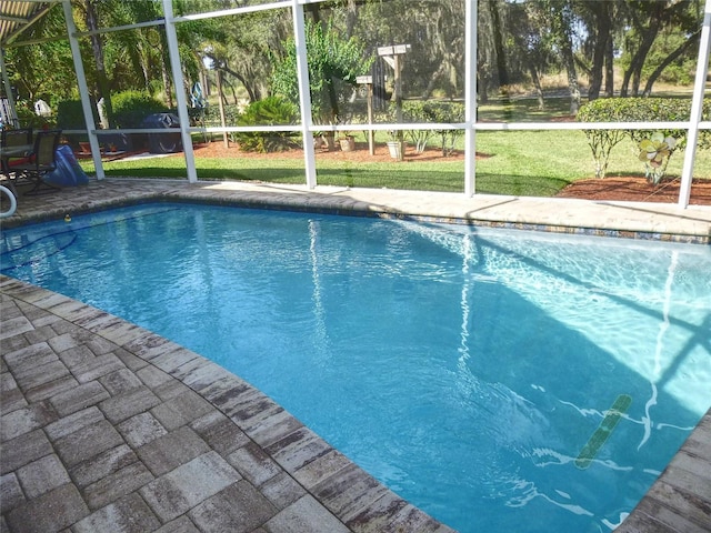 view of swimming pool with a lawn and glass enclosure