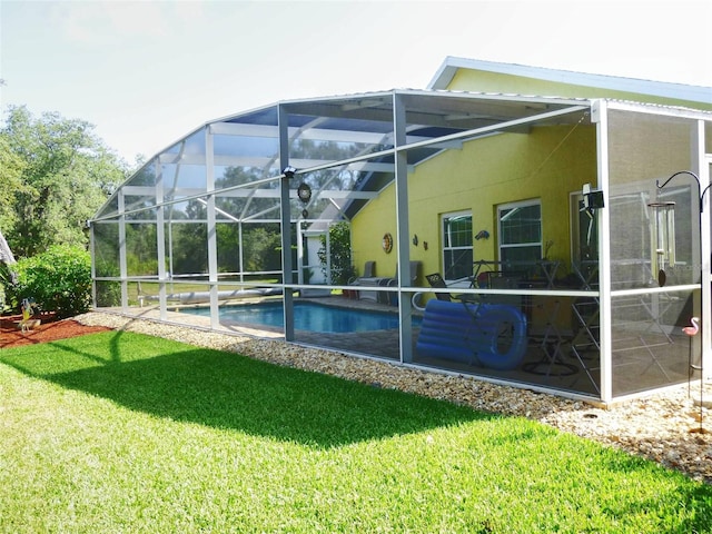 rear view of property featuring a lanai and a yard