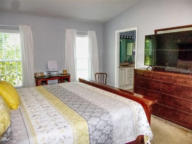 carpeted bedroom featuring vaulted ceiling, connected bathroom, and multiple windows