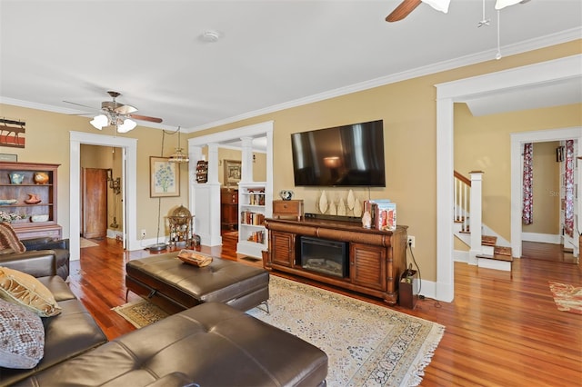 living room featuring ornate columns, ceiling fan, hardwood / wood-style floors, and ornamental molding