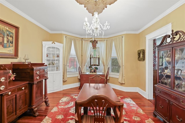 dining room featuring hardwood / wood-style floors, an inviting chandelier, and crown molding