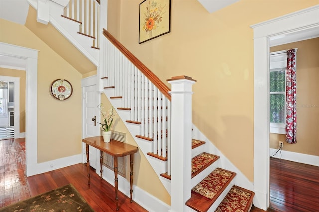 stairway featuring hardwood / wood-style flooring and vaulted ceiling