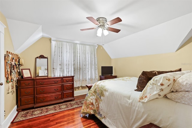 bedroom featuring ceiling fan, baseboards, lofted ceiling, and wood finished floors