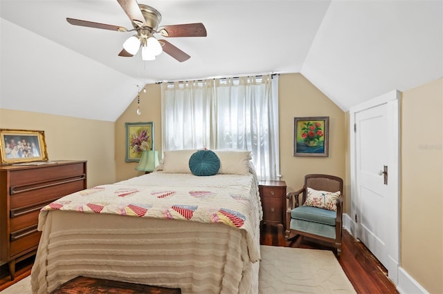 bedroom with a ceiling fan, vaulted ceiling, and wood finished floors