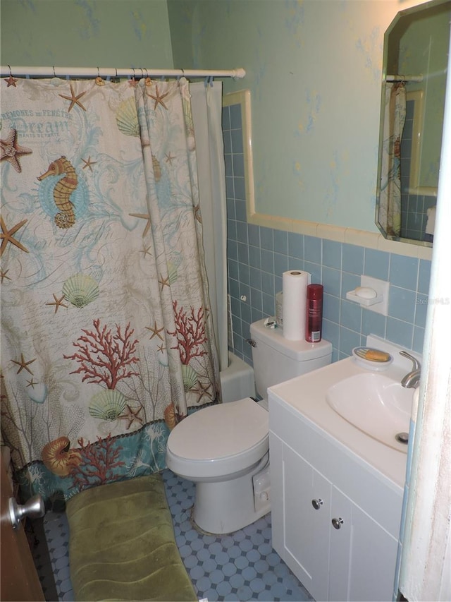 full bathroom featuring shower / bath combination with curtain, vanity, toilet, and tile walls