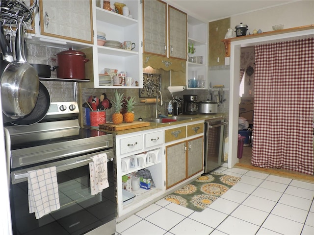 kitchen with stainless steel appliances, sink, and light tile patterned floors