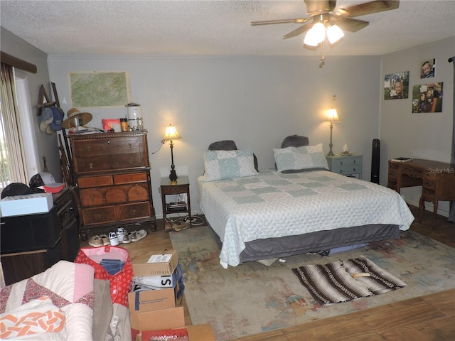 bedroom with hardwood / wood-style floors, a textured ceiling, and ceiling fan