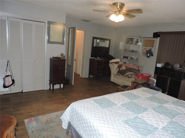 bedroom featuring dark hardwood / wood-style flooring, ornamental molding, ceiling fan, a textured ceiling, and a closet