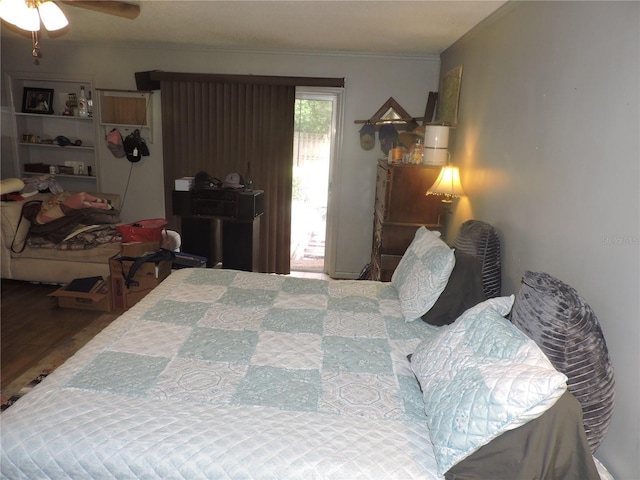 bedroom featuring hardwood / wood-style floors, crown molding, and access to outside