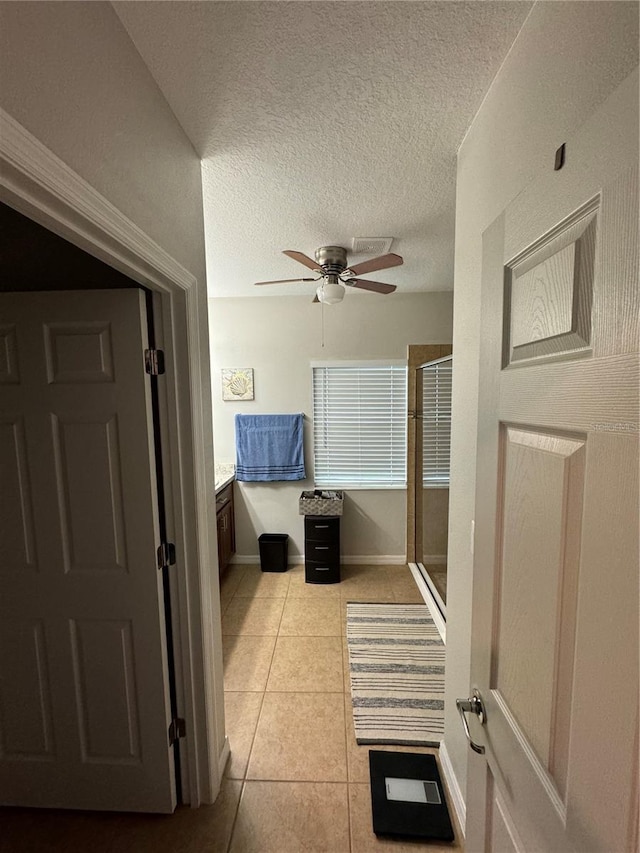 interior space featuring a textured ceiling and light tile patterned flooring