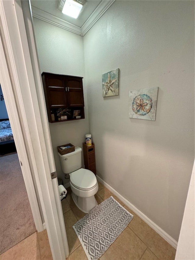 bathroom featuring tile patterned flooring, toilet, and crown molding