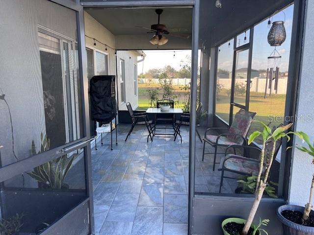 sunroom / solarium featuring ceiling fan