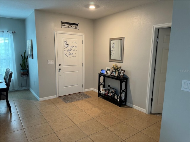 foyer entrance featuring light tile patterned floors and a textured ceiling