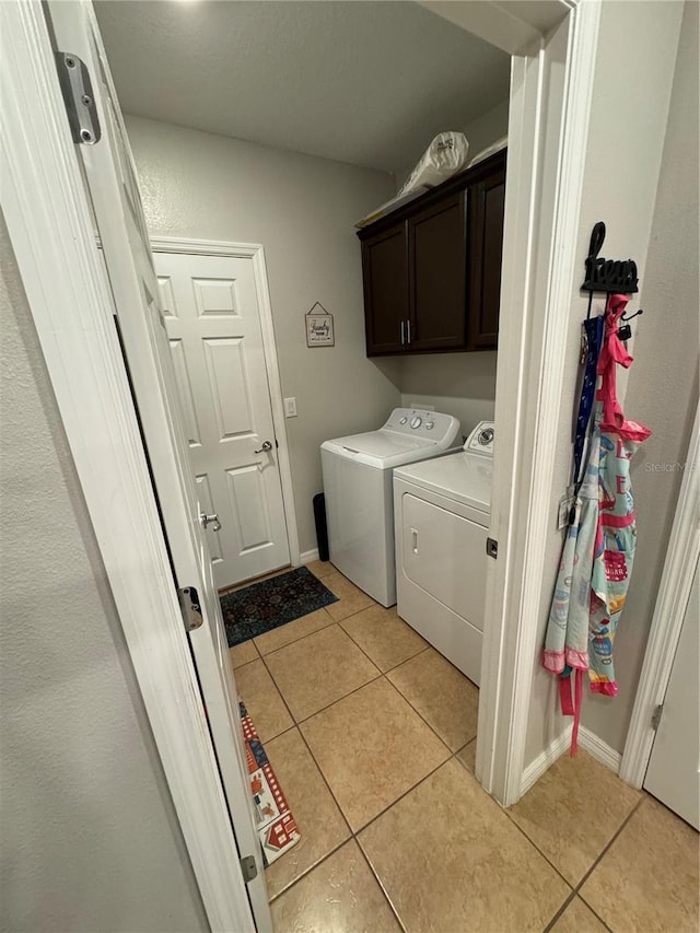 laundry room with separate washer and dryer, light tile patterned flooring, and cabinets