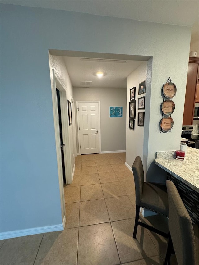 corridor featuring light tile patterned floors