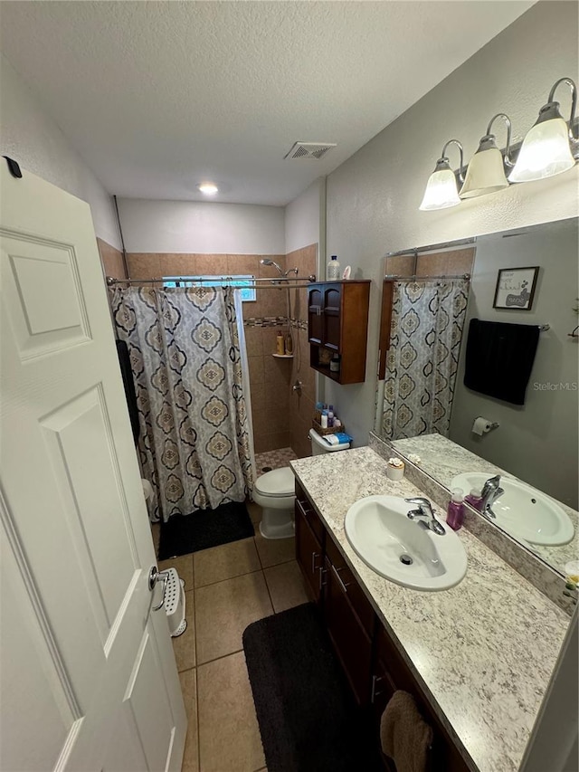 bathroom with vanity, tile patterned floors, a shower with curtain, toilet, and a textured ceiling