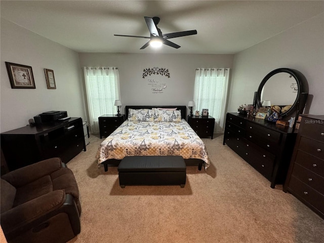 bedroom with ceiling fan, light colored carpet, and multiple windows