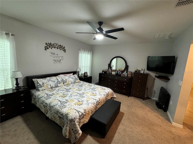 carpeted bedroom with ceiling fan and multiple windows