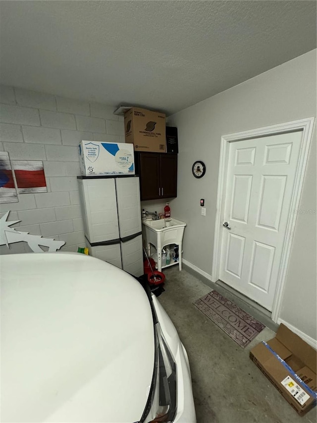 laundry room with a textured ceiling and sink