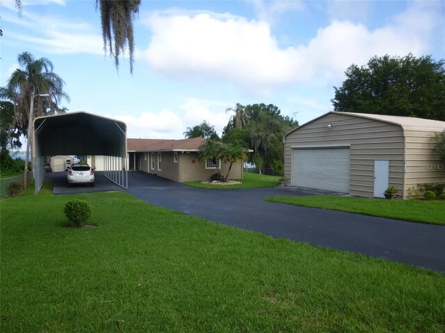 view of yard with a carport, a garage, and an outdoor structure