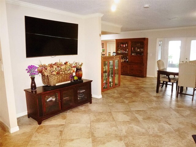 interior space featuring a textured ceiling, french doors, light tile patterned floors, and crown molding