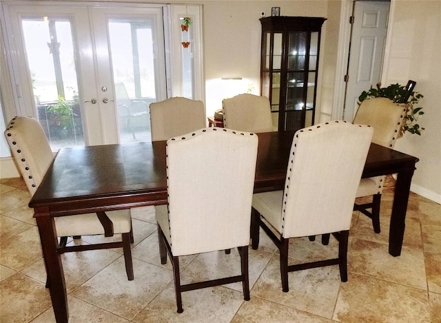 tiled dining room featuring french doors and plenty of natural light