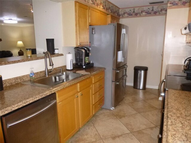 kitchen with sink, stainless steel appliances, and light tile patterned floors