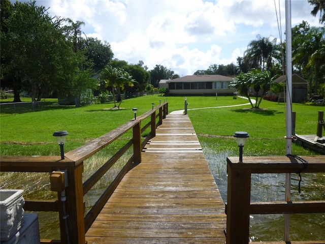 dock area featuring a lawn and a water view