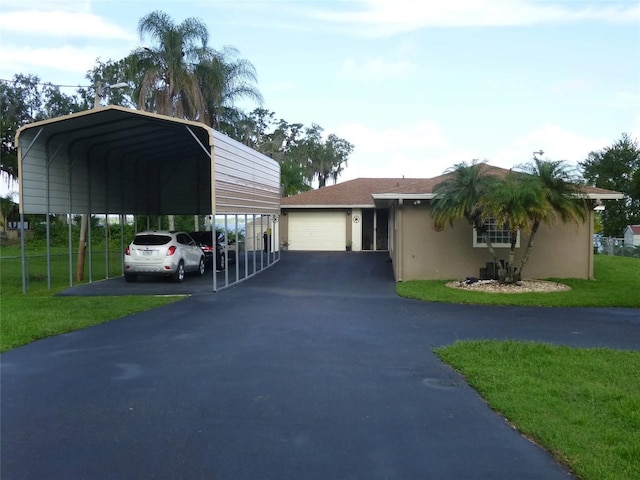 view of front facade with a garage, a carport, and a front yard