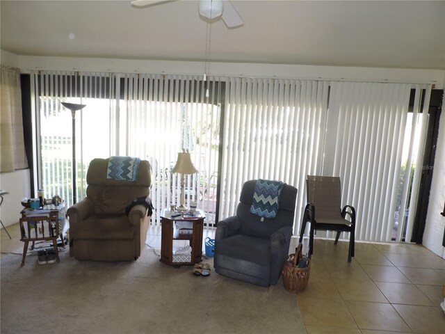 sitting room with tile patterned flooring and ceiling fan