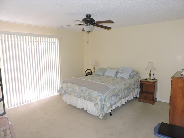 carpeted bedroom with a textured ceiling and ceiling fan