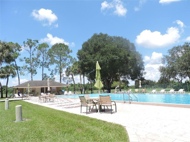 view of swimming pool featuring a patio and a lawn