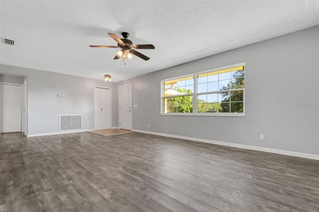 interior space featuring a textured ceiling, dark wood-type flooring, and visible vents